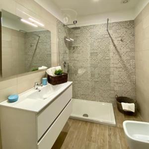 伊斯基亚Casa Maria luxury B&B的一间带水槽、浴缸和镜子的浴室