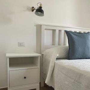 伊斯基亚Casa Maria luxury B&B的床头柜旁的白色床和蓝色枕头