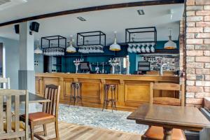 塔姆沃思OYO Tamworth Arms Boutique Pub & Hotel的餐厅内的酒吧配有桌椅