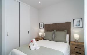 马拉加AAC Málaga - Apartamento muy cómodo y bien comunicado, a 1,3km del centro的一间卧室配有一张床,上面有两条毛巾