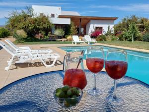 圣克鲁兹Callihue Lodge的游泳池畔的桌子上放两杯葡萄酒
