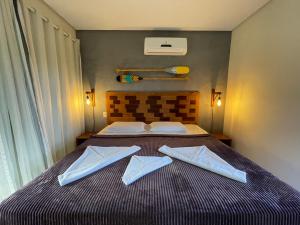 伊塔卡雷Pousada Villa Dos Sonhos的一间卧室配有一张床,上面有两条毛巾