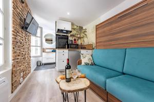 蒙托邦Chez Ingres - Le Nid - Joyau caché en centre ville的客厅配有蓝色的沙发和桌子