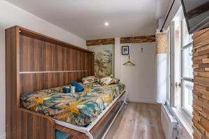 蒙托邦Chez Ingres - Le Nid - Joyau caché en centre ville的一间卧室配有一张带木制床头板的床