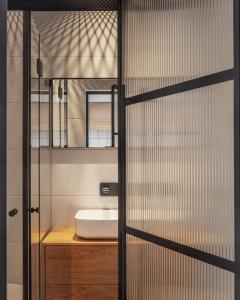 特拉维夫DeBlox living - Ben Avigdor Apartments的一间带水槽和玻璃门的浴室