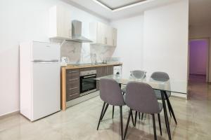 福恩吉罗拉Luxury Suite Fuengirola 1的厨房配有桌椅和冰箱。
