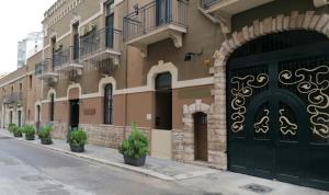 巴里Residence Hotel Moderno的街道上一座有黑色门和盆栽植物的建筑