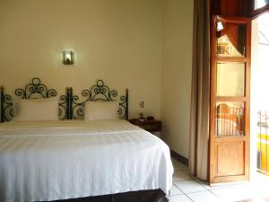 科利马Hotel Concierge Plaza Colima的一间卧室配有一张带白色床单的大床