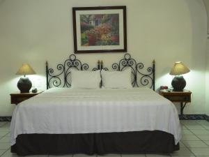 科利马Hotel Concierge Plaza Colima的一间卧室配有一张带两盏灯的大型白色床。