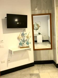 圣克鲁斯-德特内里费Hotel Océano Centro的墙上挂有镜子的墙壁和电视机