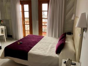 圣克鲁斯-德特内里费Hotel Océano Centro的一间卧室配有一张大床和紫色毯子