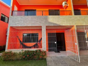 马拉戈日Casa Lua Cheia na Praia de Peroba, Maragogi的一座橙色的建筑,前面有一个门