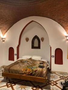卢克索Leyla Eco Resort Queen Suites的拱形客房的卧室配有一张床