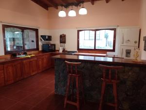 卡法亚特Cabañas Cafayate III的酒吧内的厨房,配有柜台和两个凳子