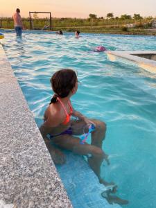 BoghişComplex Turistic Dávid的坐在游泳池里的年轻女孩