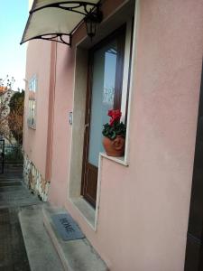 安科纳Appartamento Turistico "ortensia"的粉红色的建筑,有窗户,有盆栽植物