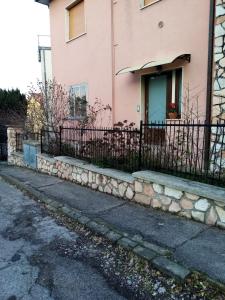 安科纳Appartamento Turistico "ortensia"的粉红色的房子,前面有栅栏