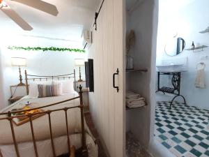 孔佩塔Casa Maroma的一间卧室配有一张床,浴室设有水槽
