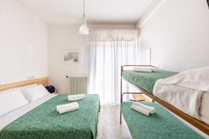 里乔内Hotel Morena Riccione Centrale的一间卧室配有两张双层床,铺有绿色床单。