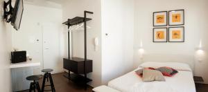 托雷坎内Via Del Faro Apartments的白色卧室配有床和凳子