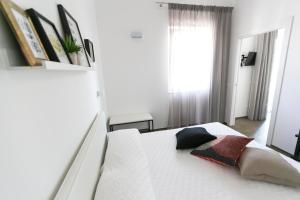 托雷坎内Via Del Faro Apartments的卧室配有白色的床和两个枕头