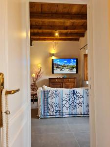 马达莱纳Residence Cala Francese - Case sul mare的一间设有一张桌子的房间,墙上配有电视