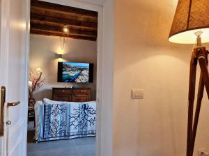 马达莱纳Residence Cala Francese - Case sul mare的走廊设有一扇门,通往带电视的客房