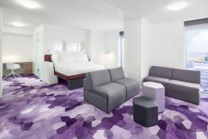 阿姆斯特丹YOTEL Amsterdam的酒店客房,配有床、沙发和椅子