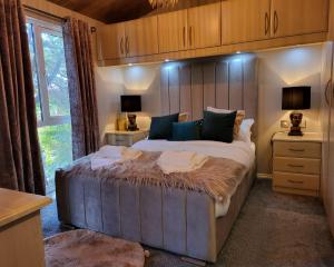 温德米尔Cheerful 3 bedroom Lodge At White cross Bay Windermere的一间卧室配有一张大床和木制床头板