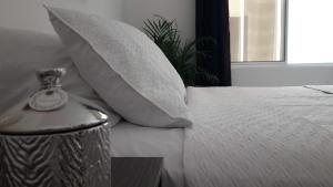 坎昆Amazing Mexican Airport Inn的一间卧室配有一张带枕头和桌子的床