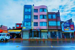 普诺Hostel Sol Andina Inn的街道边的粉红色建筑