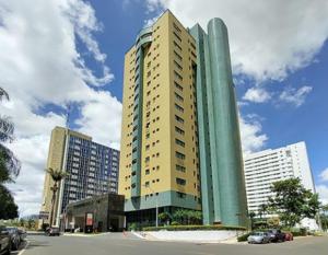 巴西利亚Quartos em alto-padrão LETs IDEA的城市里高大的建筑,前面有汽车
