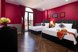 芽庄Heritage Boutique Sierra Legend的一间卧室设有两张床和红色的墙壁