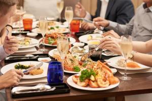 胡志明市卡拉维拉西贡酒店的一群人坐在餐桌旁,一边吃盘子