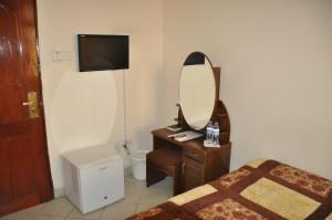阿鲁沙里奇酒店的一间带镜子、一张床和梳妆台的卧室