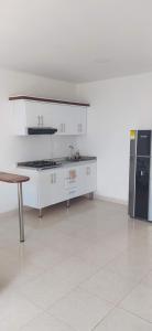 内瓦Apartaestudio Sendero Primavera的厨房配有白色橱柜和黑色冰箱。