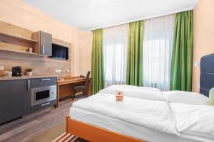 维德宁Schieners Hotel & Apfelhof Apartments的配有一张床和一张书桌的酒店客房