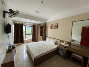 Dong QuanPhú Vinh Hotel的一间卧室配有一张床和一面大镜子
