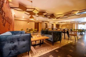 拉合尔Hotel One Tower Gulberg, Lahore的一间带沙发和桌子的餐厅以及一间用餐室