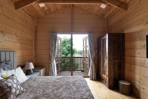 班加罗尔The Pine Loft的小木屋内的卧室配有一张床和阳台