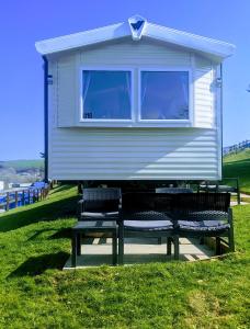 纽基4 Berth Couples and Family Caravan in Beautiful Newquay Bay Resort的一个小房子,配有两把椅子和两扇窗户