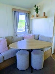 纽基4 Berth Couples and Family Caravan in Beautiful Newquay Bay Resort的客厅配有桌子和沙发