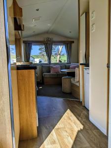 纽基4 Berth Couples and Family Caravan in Beautiful Newquay Bay Resort的享有带沙发的客厅和厨房的景色。
