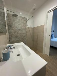 伊斯基亚Casa Maria luxury B&B的一间带白色水槽的浴室和一间卧室