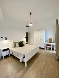 伊斯基亚Casa Maria luxury B&B的白色的卧室配有一张白色的大床和一张书桌