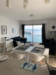 杜瓦讷内Appartement Design VIII - Port Rosmeur - Sublime vue Mer的厨房以及带桌椅的起居室。