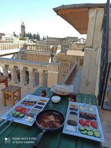 尚勒乌尔法JOSELİN HOTEL的阳台上摆放着食物盘的桌子