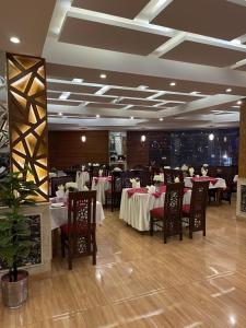 拉瓦尔品第Grand Mongolia Hotel的餐厅内带桌椅的用餐室