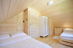 波别罗沃DOMKI Z BALA的木制客房内的一间卧室配有两张床