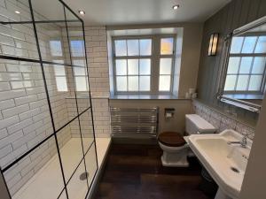伍德斯托克旁池鲍尔宾馆的带淋浴、卫生间和盥洗盆的浴室